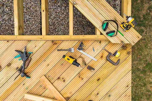 Deck building tools and lumber arranged on a wood deck during the construction process in Wylie, TX